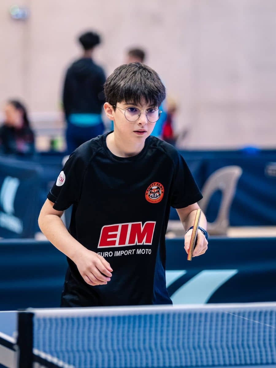 Jeune joueur portant le maillot du club et les logos partenaires